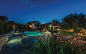 une arrière-cour avec une piscine la nuit dans l'établissement Two-Bedroom Holiday Home In Zemunic Gornji, à Vlašnović