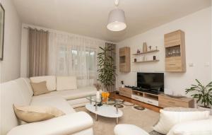 a living room with white furniture and a tv at Three-Bedroom Holiday Home In Vinjani Gornji in Aračići