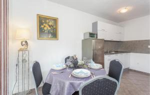 a kitchen with a table with chairs and a table cloth on it at Cozy Apartment In Sveti Vid-Miholjice in Sveti Vid-Miholjice