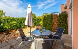 a patio with a table and an umbrella at Cozy Apartment In Sveti Vid-Miholjice in Sveti Vid-Miholjice +27 photos
