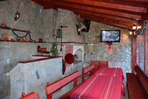 a restaurant with two tables and a tv on a stone wall at Family Hotel Diana in Lyaskovo