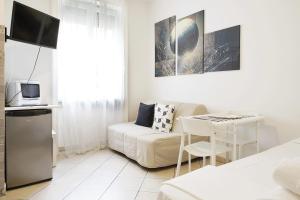 un soggiorno bianco con un divano e un tavolo di MICHELANGELO 26 Monolocale a Milano
