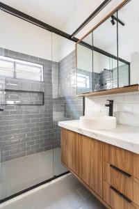 a bathroom with a sink and a glass shower at CasaAzul Moderna&Confortável Campinas in Campinas