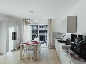 a white kitchen with a table and a dining room at Avornic's House in Porto Santa Margherita di Caorle