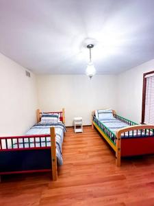 a bedroom with two beds and a wooden floor at 2000 square feet of comfort and relaxation near NYC in South River