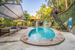 an outdoor swimming pool with a patio and a house at Boutique Hotel Las Cascadas in Manuel Antonio