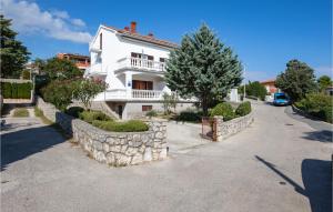 a white house with a stone fence in front of it at Cozy Apartment In Krk With Wifi in Krk +14 photos