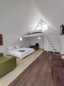 a white bedroom with a bed and a staircase at Ciwidey Hills & Wetland Family 1 in Bandung
