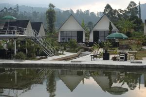 a house by the water with a slide in front at Ciwidey Hills & Wetland Family 1 in Bandung