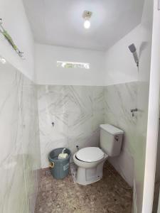 a bathroom with a toilet and a trash can at Ciwidey Hills & Wetland Family 1 in Bandung