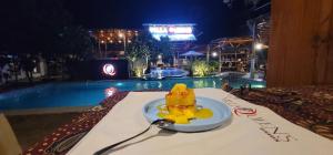 a plate of food on a table next to a pool at Bunaken Guesthouse The Queen's in Bunaken