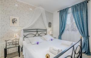 a bedroom with a large bed with blue curtains at Nice Home In Njivice With Wifi in Njivice
