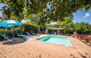 a swimming pool with two chairs and an umbrella at Lovely Home In Casole D'elsa in Casole dʼElsa