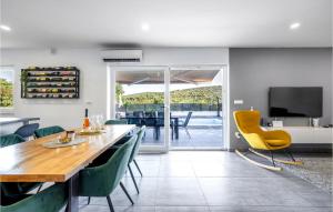 a dining room with a wooden table and green chairs at Stunning Home In Krusevo in Kruševo