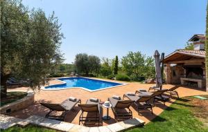 un patio avec des chaises et une piscine dans l'établissement Villa Pilato, à Vižinada