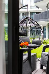 Una silla colgante con flores en un patio. en Stegna Amber Apartment, en Stegna