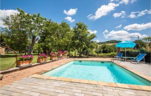 a swimming pool with two chairs and an umbrella at Lovely Home In Casole D'elsa in Casole dʼElsa +29 photos