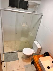 a bathroom with a shower and a toilet and a sink at Cond Praia Da Perola - Apt Rosa 7 in Ilhéus