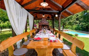 einen langen Holztisch in einem Pavillon mit in der Unterkunft Cozy Home In Kupljenovo in Kupljenovo