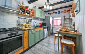 eine Küche mit grünen Schränken und einem Tisch darin in der Unterkunft Cozy Home In Kupljenovo in Kupljenovo