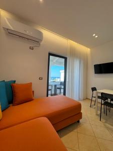 a living room with a couch and a table with chairs at Villa White in Ksamil