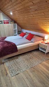 a large bed with red pillows in a bedroom at Privát JOZEF in Vrbov