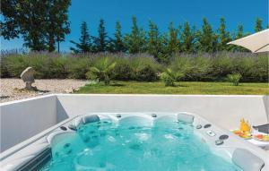 a bath tub in a garden with a bird sitting on the grass at Beautiful Home In Nedescina in Nedeščina +29 photos