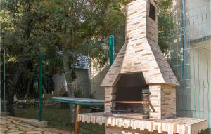 a brick pizza oven sitting next to a green table at Lovely Apartment In Pavicini With Wifi in Pavicini +12 photos