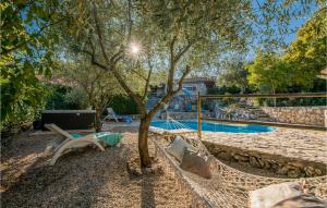 amaca sotto un albero accanto alla piscina di Amazing Home In Dobrinj a Dobrinj