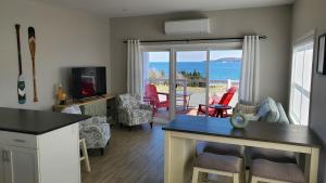 a kitchen and living room with a view of the ocean at Ocean Breeze in Ingonish Beach