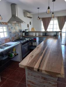 a large kitchen with a wooden counter top in it at El retiro, casa de campo in San Antonio de Areco