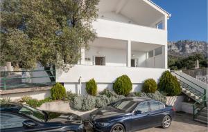 two cars parked in front of a house at 1 Bedroom Awesome Apartment In Podaca in Podaca