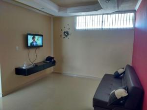 a living room with a couch and a tv on a wall at Bello Apartamento Vacacional Casa caribe Isla de Margarita in Porlamar +1 photo