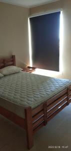a large bed in a room with a window at Bello Apartamento Vacacional Casa caribe Isla de Margarita in Porlamar