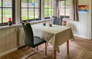 a dining room with a table and two chairs and windows at Cozy Home In Burg Stargard With Wifi in Burg Stargard
