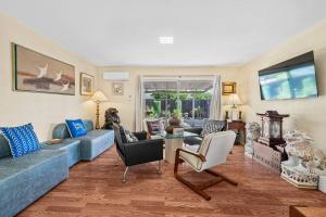 ein Wohnzimmer mit einem blauen Sofa und Stühlen in der Unterkunft Beauty Supplies 3Br house for Family in Fremont in Fremont