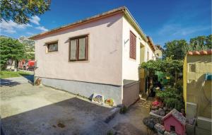 a small white house with a yard at 1 Bedroom Amazing Apartment In Karlobag in Karlobag +14 photos
