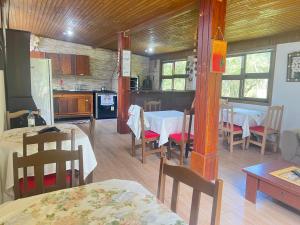eine Küche und ein Esszimmer mit Tischen und Stühlen in der Unterkunft Morada Fênix in Guarda do Embaú