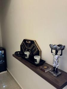 a shelf with two cups and a statue on it at استديو هادئ in Riyadh