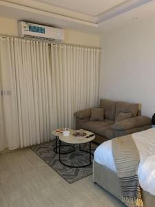 a hotel room with a bed and a couch and a table at استديو هادئ in Riyadh +6 photos