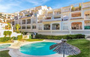 a large apartment building with a swimming pool and an umbrella at 24, Blo 2B-A in Nerja
