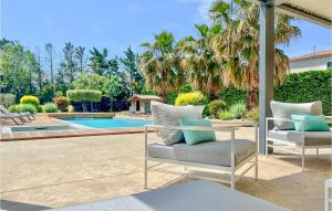 a patio with two chairs and a swimming pool at Cozy Home In Maillane With Kitchen in Maillane