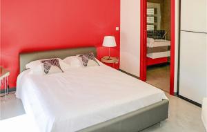 a bedroom with a white bed with a red wall at Cozy Home In Maillane With Kitchen in Maillane
