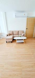 a living room with a couch and a coffee table at The pink palace in Karon Beach