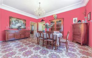 jadalnia z różowymi ścianami, stołem i krzesłami w obiekcie Villa Gaia w mieście Menfi