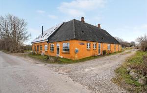 una casa arancione sul lato di una strada sterrata di Stunning Apartment In Skårup Fyn a Skårupøre