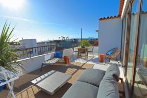 eine Terrasse mit einer Couch und einem Tisch auf einem Balkon in der Unterkunft Octopus House Caparica in Costa da Caparica