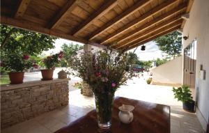 een vaas met bloemen op een tafel onder een dak bij Apartment Pazin 10 in Katun Lindarski