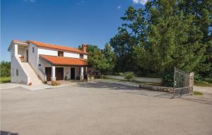 een wit huis met een poort en een oprit bij Apartment Pazin 10 in Katun Lindarski