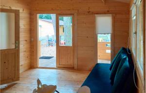 Habitación de madera con sofá azul y puerta en 1 Bedroom Nice Home In Pobierowo, en Pobierowo